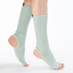 Side view of a woman's leg wearing Aqua color of Knitido plus brand's Botanical Dyed Organic Cotton Open Toe/Heel Yoga Socks