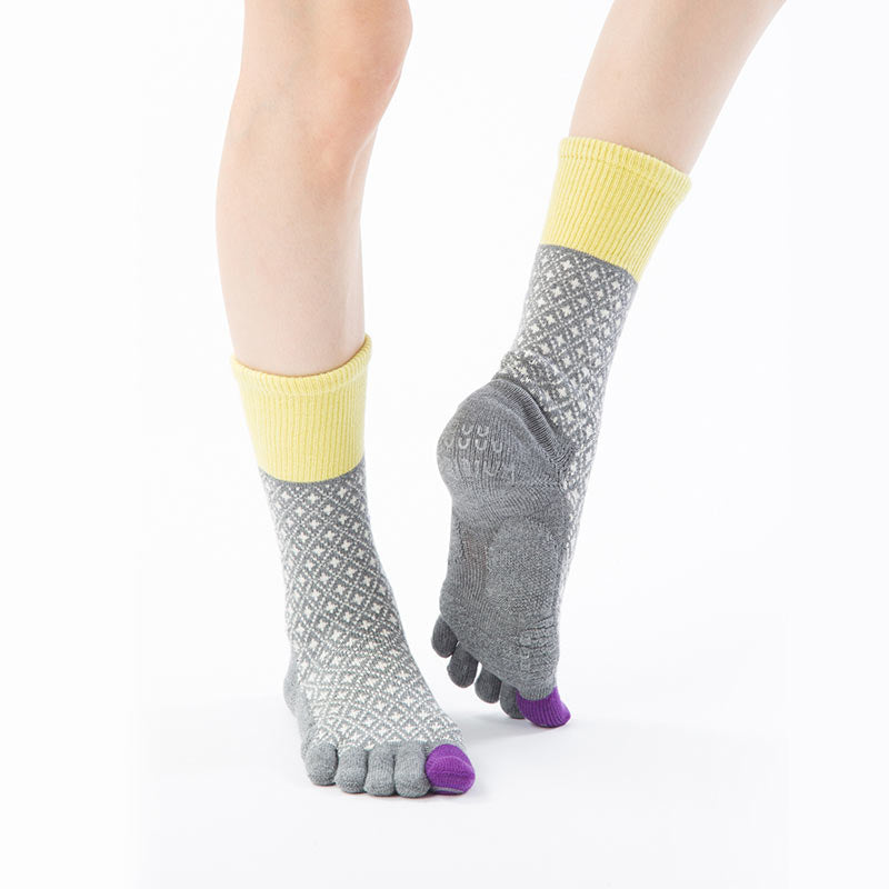 Front view of a woman wearing Knitido plus brand Diamond Midcalf Grip Toe Socks With Power Pads in Grey (with yellow and purple inserts)