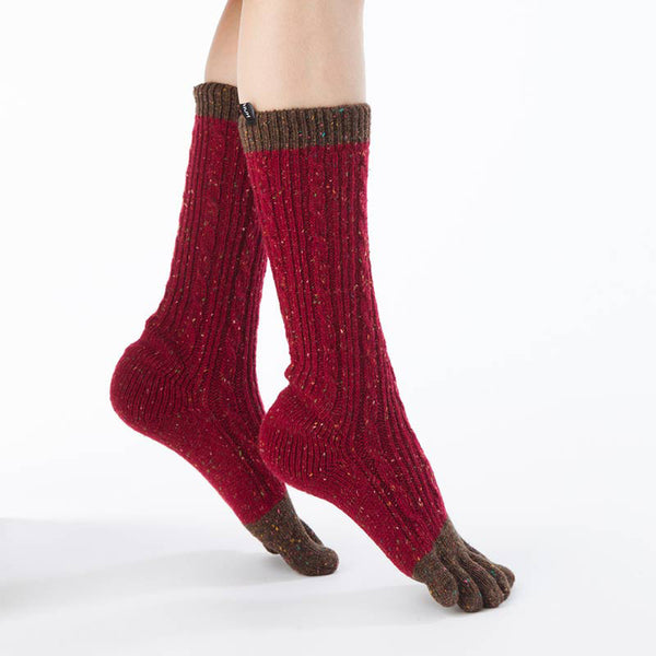 Side view of a woman's leg wearing a pair of Knitido plus brand Wool Blend Cable Confetti Midcalf Toe Socks in a red color with khaki inserts at the toe and cuff of the foot